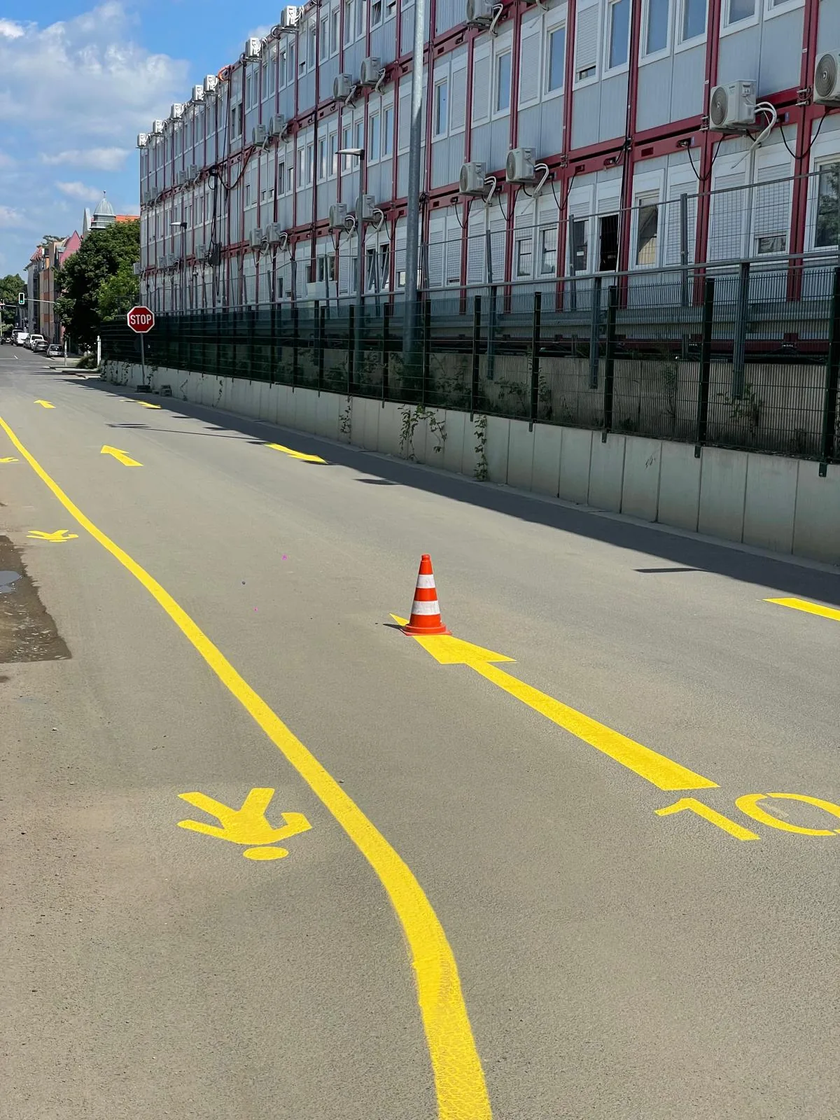 Gelbe Fahrbahnmarkierungen mit Linien und Richtungspfeilen